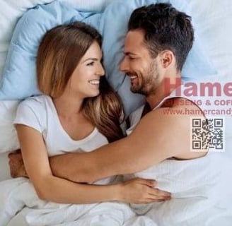 a man and woman are smiling and hugging in bed hamer candy