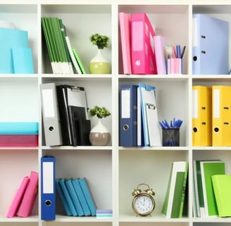 a bookcase with many different colored binders