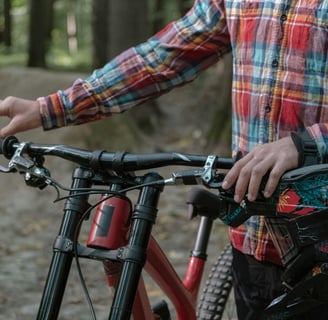 a man in a plaidered shirt and a bicycle
