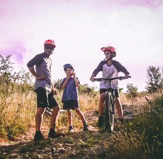 a man and two children on a mountain bike