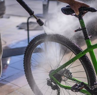 a man is using a spray gun to clean a bike
