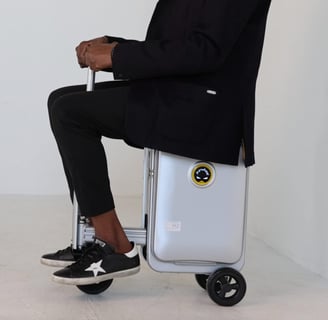 a man sitting on a suitcase with a suitcase