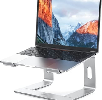 a laptop computer sitting on a stand up