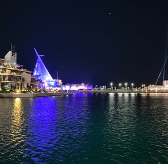 a boat in the water with a sailboat in Jeddah Corniche, Saudi Arabia