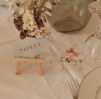 Numéro de table en argile sur chevalet avec fleurs séchées 