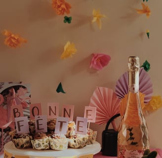 Bonne fête maman sur des muffins avec des fleurs flottantes en arrière plan et une bouteille