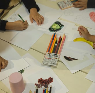 a group of children's hands are drawing on paper