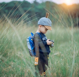 a young boy in a hat and a backpacker