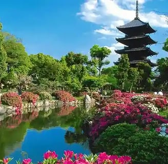 Temple indou au bord d'un bassin d'eau bordé de grands arbres et de fleurs