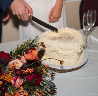 Bedfordshire bride and groom poised with knife ready to cut their cream decorated wedding cake