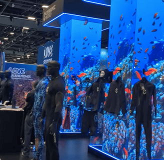 scuba dive mannequins in front of big convention columns showing a dive video