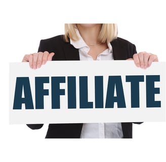 donna freelance che regge un cartello con scritto affiliate marketing 2025