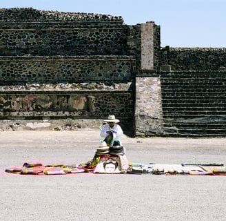 a man in a hat selling hats on a blanket