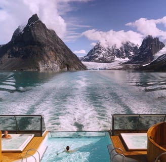 a person swimming in a pool in the mountains
