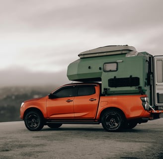 Orange Suzuki Pick-Up with camping gear