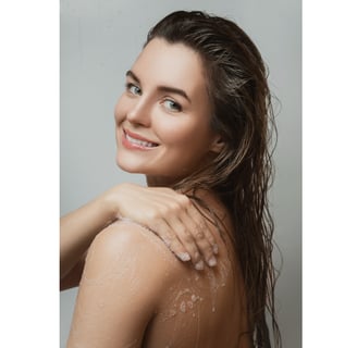 Woman using shower oil to nourish her skin as part of her skincare routine