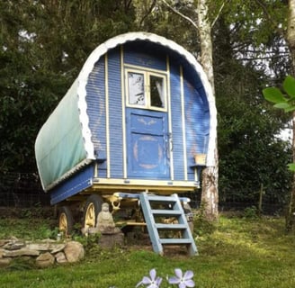 Charming blue bow top roulotte set in a peaceful forest clearing at Les Vieilles Forges