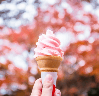a person holding a cone with pink and white swirls