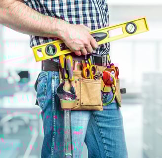 a handyman in a tool belt holding a tool belt in coquitlam