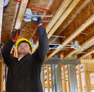 a man in a hard hat and a helmet on installing light fixture in Squamish