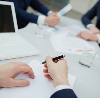 hands taking notes representing the close up of a pharmacovigilance audit