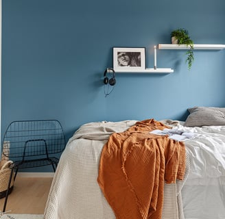 Floating shelves in a bedroom showcasing books and decor.