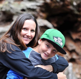 a woman and a boy are smiling and hugging