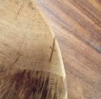 close-up of the edge of a bowl with a copper wire threading together 2 sides of a small crack