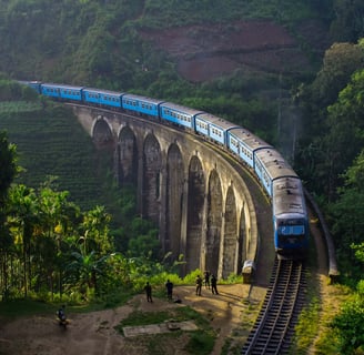 The iconic Nine Arch Bridge in Ella with a train passing through lush greenery