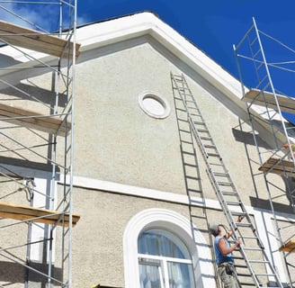 elastomeric paint being applied to a stucco building