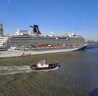 A cruise ship in background with a tugboat in foreground
