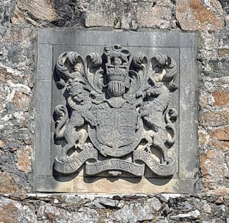 a stone wall with a coat of arms and a shield on it