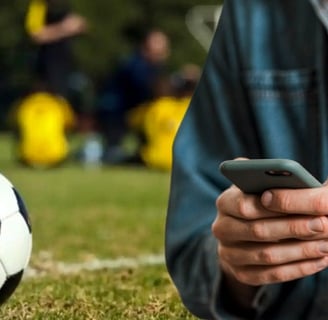 a man in a blue shirt is holding a cell phone