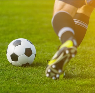  Un jugador de fútbol pateando un balón de fútbol en un campo