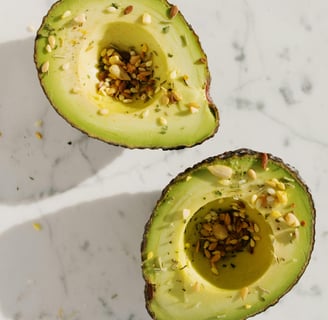 een doorgesneden avocado met zaadjes bestrooid