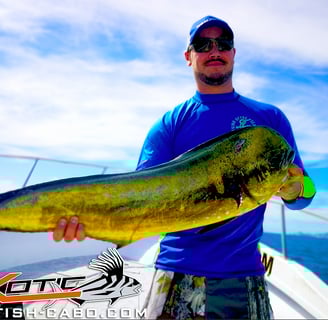 a man holding a fish fish on a boat