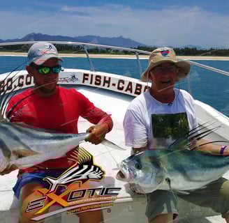 two men holding fish on a boat in the ocean