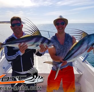 two men holding fish on a boat in the ocean