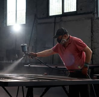 a man in a red shirt is spraying a metal table