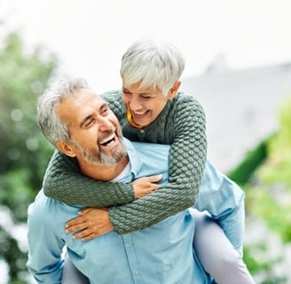 couple souriant de plus de 45 ans la femme est sur le dos de son mari