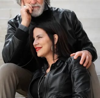 une femme de plus de 45 ans enlacé avec son mari, tous deux assis sur un escalier