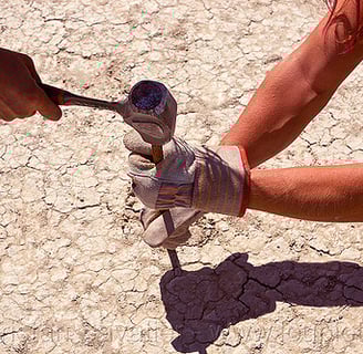 People hammering anchor to the playa dirt