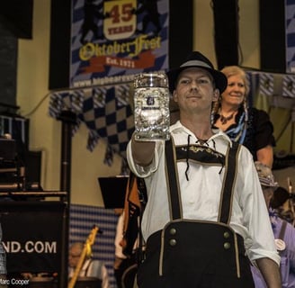 a man in a bavarian beer outfit holding a beer glass