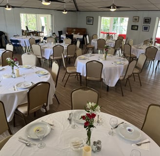 a table setting with white tablecloth and chairs