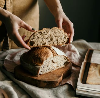 a person holding a piece of bread in their hand