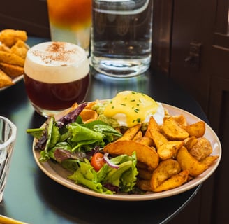 a table with a plate of food and a drink