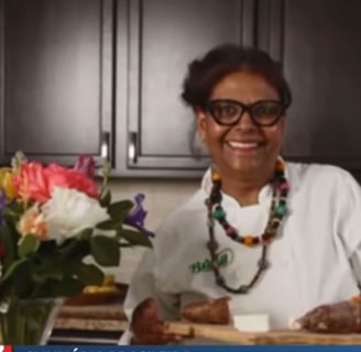 a woman in a white shirt and glasses is smiling