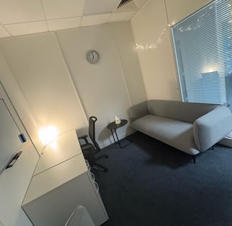 Therapy room: sofa on the right with fairy lights above, viewpoint from counselling chair