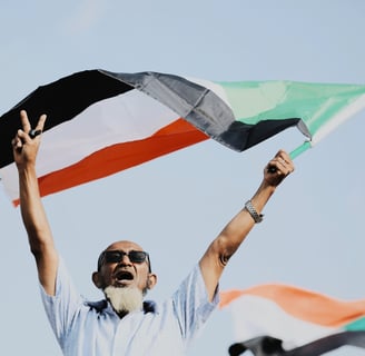 The Sounds of Sudan - cover image of a man holding the Sudanese flag