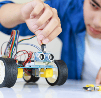 a boy is playing with a robot - controlled toy car